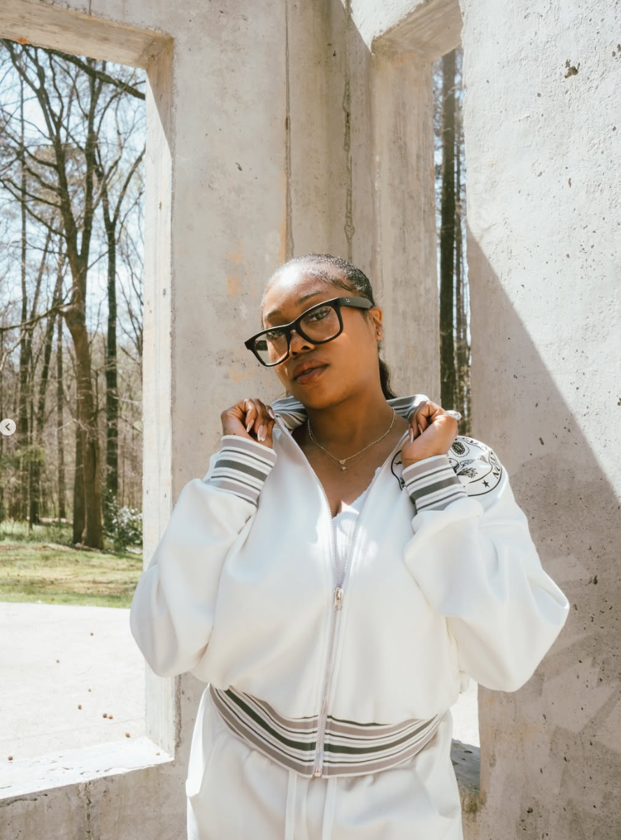Model in white Aggravated Nation tracksuit at concrete window